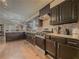 Kitchen with black appliances, stone countertops, stainless steel hood, and dark wood cabinets at 3241 Briscoe Rd, Loganville, GA 30052