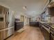 Open kitchen with stainless steel fridge, stone countertops, wood flooring and dark wood cabinets at 3241 Briscoe Rd, Loganville, GA 30052