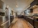 Spacious kitchen featuring stainless steel appliances, dark cabinets, and wood flooring at 3241 Briscoe Rd, Loganville, GA 30052