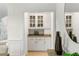 Built-in bar area with granite countertops and glass-front cabinets for showcasing glassware at 790 Thornberry Dr, Alpharetta, GA 30022