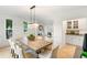 Open dining room area features a modern chandelier, large dining table and a granite bar at 790 Thornberry Dr, Alpharetta, GA 30022