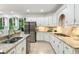 Bright kitchen features white cabinets, stainless appliances, granite countertops and breakfast bar area at 790 Thornberry Dr, Alpharetta, GA 30022
