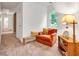 Cozy nook with an orange chair, throw blanket, and wooden shelf in a naturally lit room at 143 Navajo Trl, Rydal, GA 30171