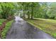 Long, winding driveway leading to a charming home surrounded by lush greenery at 143 Navajo Trl, Rydal, GA 30171