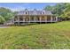 Charming home featuring a sprawling front porch with hanging plants, greenery and a swing at 143 Navajo Trl, Rydal, GA 30171