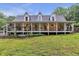 Charming home featuring a sprawling front porch with hanging plants, greenery and a swing at 143 Navajo Trl, Rydal, GA 30171