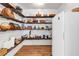 Well-stocked pantry with ample shelving, baskets, food, a mini fridge, and wood-look flooring at 143 Navajo Trl, Rydal, GA 30171