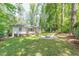 Spacious backyard featuring a stone fire pit, surrounded by lush greenery and mature trees at 1992 Cascade Sw Rd, Atlanta, GA 30311