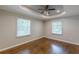 Bright bedroom featuring hardwood floors, tray ceiling, and ample natural light at 1992 Cascade Sw Rd, Atlanta, GA 30311