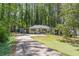 Long driveway leading to a charming one-story home surrounded by lush trees at 1992 Cascade Sw Rd, Atlanta, GA 30311