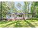 Charming single story home with a wooden deck and lush green lawn surrounded by mature trees at 1992 Cascade Sw Rd, Atlanta, GA 30311