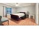 Main bedroom featuring wood floors, ceiling fan, and tufted, king-size bed at 2203 Beacon Crest Dr, Buford, GA 30519