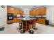 Open kitchen with a center island, oak cabinets, tile floors, and black appliances at 10 Bunker Lane St, Covington, GA 30014