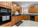 Kitchen with oak cabinets, black appliances, and tile backsplash at 10 Bunker Lane St, Covington, GA 30014