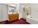 Bright bathroom featuring double sink vanity, shower, and a soaking tub at 10 Bunker Lane St, Covington, GA 30014