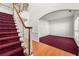 Carpeted staircase leading to an open area with hardwood flooring and archway to the living room at 10 Bunker Lane St, Covington, GA 30014