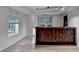 Finished basement with custom bar with unique wood design and natural light from windows at 1635 Rushing River Way, Suwanee, GA 30024