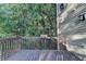 A backyard wood deck overlooks lush greenery providing a secluded retreat from this home's exterior at 1635 Rushing River Way, Suwanee, GA 30024