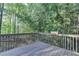 Relaxing wooden deck with wooded views provides a private outdoor space for entertaining or unwinding at 1635 Rushing River Way, Suwanee, GA 30024