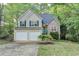 Charming two-story home with a two-car garage and well-maintained front yard, complemented by lush greenery at 1635 Rushing River Way, Suwanee, GA 30024