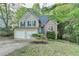Charming two-story home with a two-car garage and well-maintained front yard, complemented by lush greenery at 1635 Rushing River Way, Suwanee, GA 30024