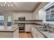 Bright kitchen features white cabinets, stainless steel appliances, and granite countertops at 1635 Rushing River Way, Suwanee, GA 30024