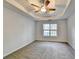 Spacious main bedroom with a tray ceiling, ceiling fan, and large window at 1635 Rushing River Way, Suwanee, GA 30024