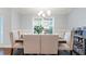 Elegant dining room with a wooden table, upholstered chairs, and natural light from a large window at 505 Alta Ct, Villa Rica, GA 30180