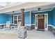 Inviting front porch featuring rocking chairs, stone pillars, and a dark wooden door with decorative sidelights at 505 Alta Ct, Villa Rica, GA 30180