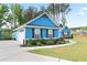 Side view of the blue house showcasing a two-car garage with a well-maintained lawn and tasteful landscaping at 505 Alta Ct, Villa Rica, GA 30180