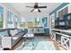 Bright sunroom has multiple windows, ceiling fan, hardwood floors and comfortable seating at 505 Alta Ct, Villa Rica, GA 30180
