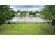 Spacious backyard with green lawn, a charming fence, and views of the neighborhood lake at 1692 Holcomb Lake Rd, Marietta, GA 30062