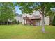 Well-maintained backyard with a spacious lawn, a wooden deck, and mature trees, perfect for outdoor activities at 1692 Holcomb Lake Rd, Marietta, GA 30062