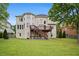 Large backyard showing a two-story home with a wooden deck, expansive lawn, and lush greenery, ideal for entertaining at 1692 Holcomb Lake Rd, Marietta, GA 30062