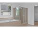 Bright bathroom with a glass-enclosed shower, a luxurious soaking tub, and an adjacent walk-in closet at 1692 Holcomb Lake Rd, Marietta, GA 30062