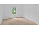 Bright, carpeted bedroom featuring a window with natural light, neutral paint, and minimalist decor at 1692 Holcomb Lake Rd, Marietta, GA 30062
