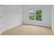 Carpeted secondary bedroom featuring a window with natural light, neutral paint, and minimalist decor at 1692 Holcomb Lake Rd, Marietta, GA 30062
