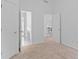 This carpeted bedroom has an open doorway to an ensuite bathroom with a vanity and tile floor at 1692 Holcomb Lake Rd, Marietta, GA 30062