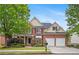 Charming two-story home featuring a well-manicured lawn, two-car garage, and a classic brick facade at 1692 Holcomb Lake Rd, Marietta, GA 30062