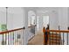 Upstairs hallway features neutral carpet, wood railing with black metal spindles, and views into other rooms at 1692 Holcomb Lake Rd, Marietta, GA 30062