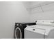 Laundry room featuring a front-loading washing machine, dryer, and wire shelving for storage at 1692 Holcomb Lake Rd, Marietta, GA 30062