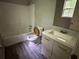Bathroom featuring a tub/shower combo, white vanity, and wood look flooring at 2756 Del Ridge Dr, Douglasville, GA 30135
