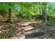 Backyard brick patio sitting area with stone steps and bench offers a quiet outdoor space at 2978 Legislative Ln, Buford, GA 30519