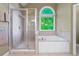 The bathroom features a separate shower and soaking tub with a bright arched window at 2978 Legislative Ln, Buford, GA 30519
