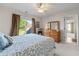 Bright bedroom with carpet, ceiling fan, dresser, and slider door to backyard at 2978 Legislative Ln, Buford, GA 30519
