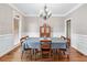 Formal dining room featuring hardwood floors, wainscoting, and traditional chandelier lighting at 2978 Legislative Ln, Buford, GA 30519