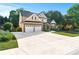 Two-story house featuring a large driveway, a two-car garage and mature trees at 2978 Legislative Ln, Buford, GA 30519