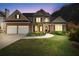Two-story home featuring a well-manicured lawn, a two-car garage, and a charming front porch at 2978 Legislative Ln, Buford, GA 30519
