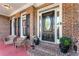 Charming brick front porch with seating, potted plants, and an elegant front door at 2978 Legislative Ln, Buford, GA 30519