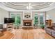 Cozy living room features a stone fireplace, hardwood floors, and large windows overlooking the backyard at 2978 Legislative Ln, Buford, GA 30519